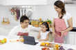 © xreflex - Happy Asian family make a cooking. Father, Mother and Daughter are preparing fruit orange and see Digital tablet in the kitchen at home. Healthy food concept and happy holidays