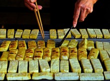 Hands Grilling Plenty Of Chinese Tofu Arranged Neatly On The Stove Waiting To Be Served To Customers.