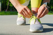 © fotofabrika - Woman runner tying her shoes laces preparing for a morning run