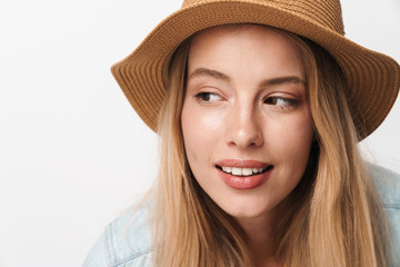 Wall Mural - Flirty amazing young pretty woman wearing hat posing isolated over white wall background looking at copyspace.