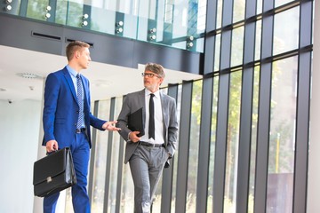 Wall Mural - Businessmen discussing while walking at office