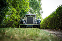 Classic Wedding Car Driving On Driveway With Grass And Hedge