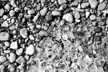 Stones On The River Bank With Ice In The Spring. Stone Coast And Ice