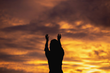 Wall Mural - Women raise their hands Pray to God who dwells on the Blue Heaven.Silhouette style