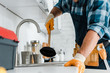 © LIGHTFIELD STUDIOS - cropped view of repairman holding plunger in kitchen