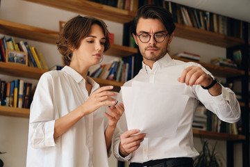 Aufkleber - Young thoughtful business colleagues standing with papers and discussing new project together in office