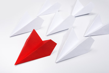 Group of white paper plane in one direction and one red paper plane pointing in different way on white background. Business for innovative