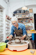 © BGStock72 - Senior female potter working on pottery wheel while sitting  in her workshop