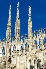 Wall Mural - White marble statues on the roof of famous Cathedral Duomo di Milano in Italy