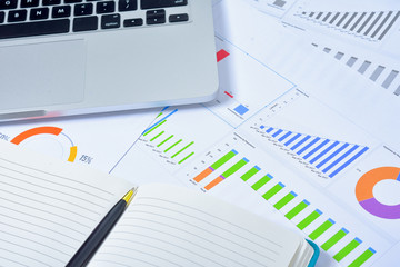 Business and Finances Concepts. Laptop, Notebook with graph and pen