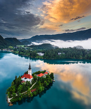 Bled, Slovenia - Beautiful Aerial View Of Lake Bled (Blejsko Jezero) With The Pilgrimage Church Of The Assumption Of Maria On A Small Island And Dramatic Reflecting Clouds And Sky At Summer Time