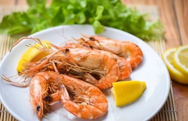 shrimp grilled bbq seafood on white plate table food - prawns shrimps cooked burnt barbecue with lemon and vegetable salad