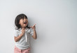 asian cute little girl surprised with finger pointing in isolated background