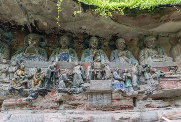 Wall Mural - Buddha busts at Dazu Rock Carvings at Mount Baoding or Baodingshan in Dazu, Chongqing, China. Sculpture below shows great parental love and grace. UNESCO World Heritage Site.