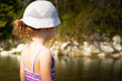 © silvia - Little child girl looking a river wearing white hat and suit. Back view, copy space.