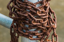 Old Rusty Chains On A Steel Pole.