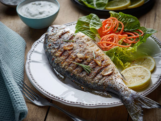 Poster - grilled fish on wooden kitchen table