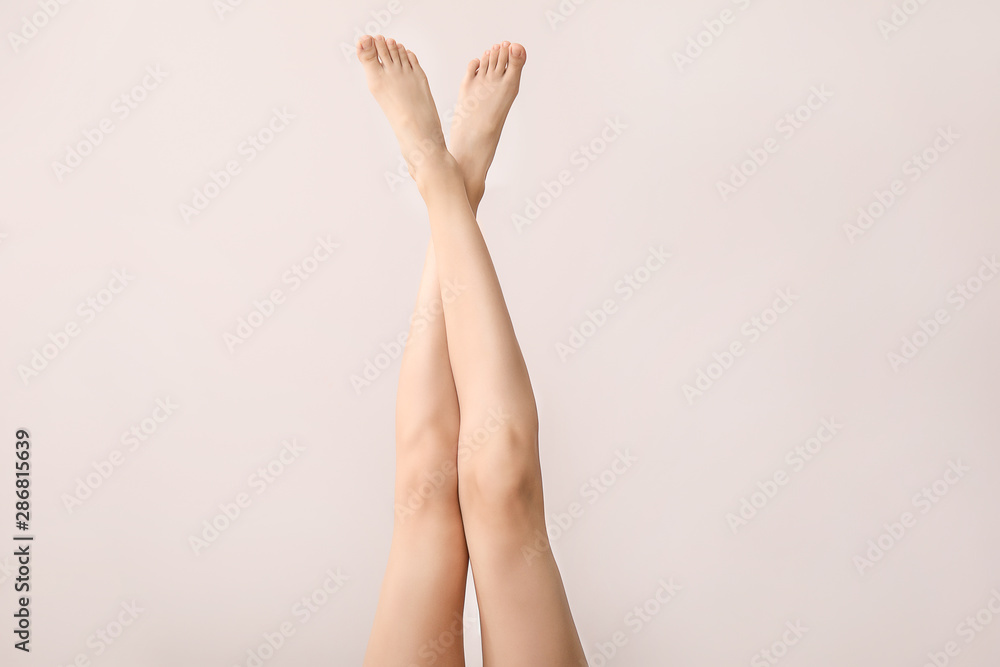 Legs of beautiful young woman on light background