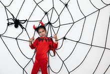 Young Girl In Red Devil Suit With Cobweb,halloween Concept.