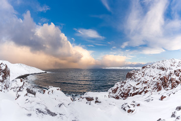 Wall Mural - winter panorama of barents sea gulf surrounded by snow covered rocky shores in the far north above t