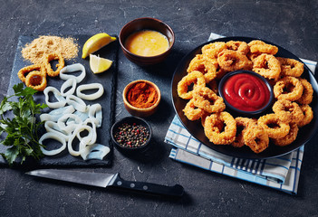 Canvas Print - crispy calamari rings on a black plate