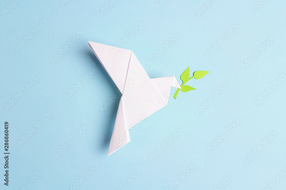 Paper origami dove of peace with olive branch on a blue background. - obrazy, fototapety, plakaty 