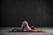Young woman doing yoga exercise Uttana shishosana or extended puppy pose. Studio shot