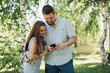 Couple using smartphone in birch forest