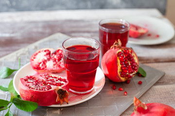 Pomegranate juice with fresh pomegranate fruits on wooden table