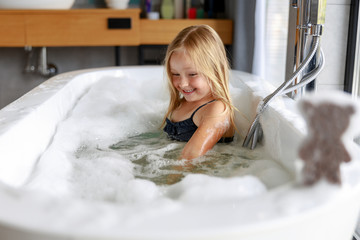 Wall Mural - Happy cute girl is swimming in a swimsuit