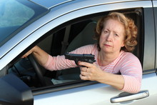 Senior Female Driver Holding A Gun 