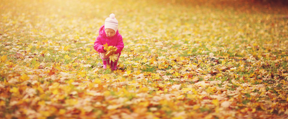 Child standing with umbrella in beautiful autumnal day