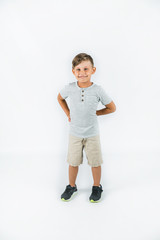 Wall Mural - Little boy with autism standing on a white background feeling happy and smiling