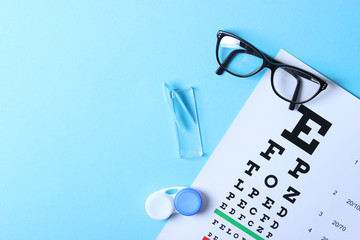 a table for checking vision, glasses and lenses for correcting vision on a colored background, top view. Ophthalmologist Accessories.