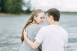 © pavelvozmischev - a walk in the woods by the pier. young couple walking on the lake.