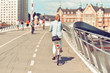 Woman cyclist in casual wear rides on bicycle by city. Photo in vintage style.