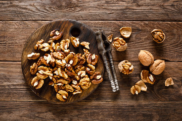 Sticker - Walnuts. Kernels and whole nuts on wooden rustic table, top view