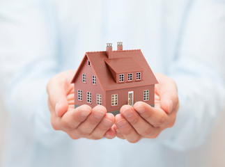 Poster - Small brown toy house in hands 