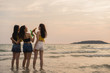 © tirachard - Group of Asian teenage girls having party celebrating on beach, friends happy drinking beer on beach at sea when sunset in evening. Outdoor activity friends travel holiday vacation summer concept.