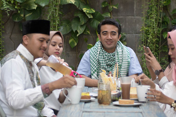 Wall Mural - group of happy young muslim having dinner outdoor