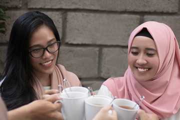 Wall Mural - group of friends having tea toast at table dining during ramadan celebration