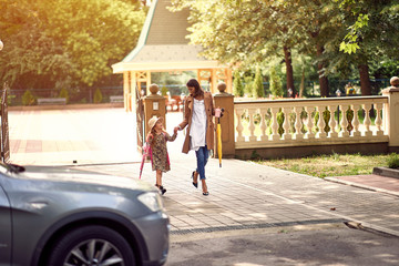 Wall Mural - schoolgirl going back to school. Mother and kid going to school..