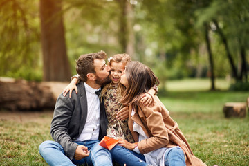 Wall Mural - Happy childhood - parents kissing their little child.