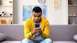 African-American teenager playing viral game on smartphone, gadget addiction