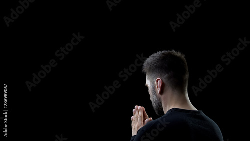 Fotomural Praying man on black background, sins forgiveness, spiritual inspiration, help