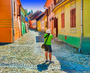 Wall Mural - tourist taking photos in Sighisoara medieval city. Romania