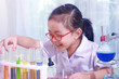 © Stella - Little asian girl doing experiments in the laboratory. Cool kid studying chemistry science, Child pretending to be scientist and has fun in lab.