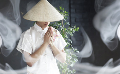 Asian man in a kimono prays with a book