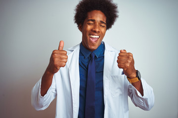 Poster - Young african american doctor man wearing coat standing over isolated white background excited for success with arms raised and eyes closed celebrating victory smiling. Winner concept.