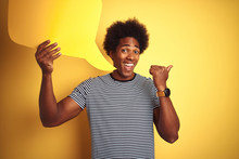 Young African American Man Holding Speech Bubble Standing Over Isolated Yellow Background Pointing And Showing With Thumb Up To The Side With Happy Face Smiling